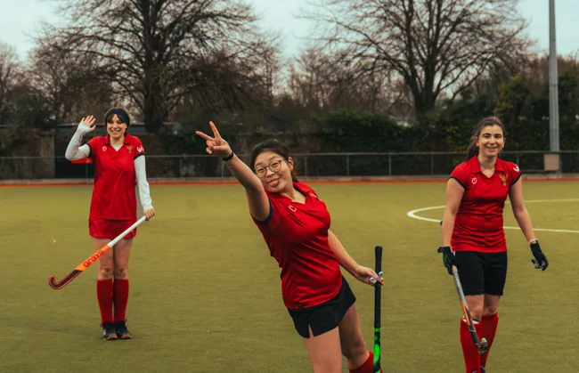 Hockey players celebrating on the pitch.
